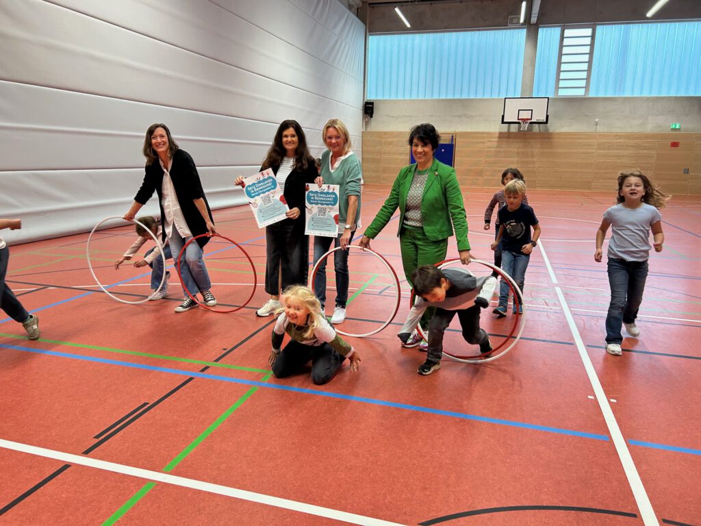 Erwachsene und Kinder beim Spiel in einer Turnhalle