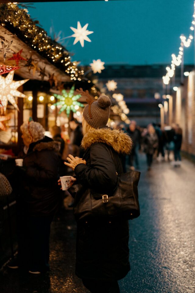 Eine Frau besucht einen Weihnachtsmarkt in Dinslaken und schaut sich einer der Hütte an