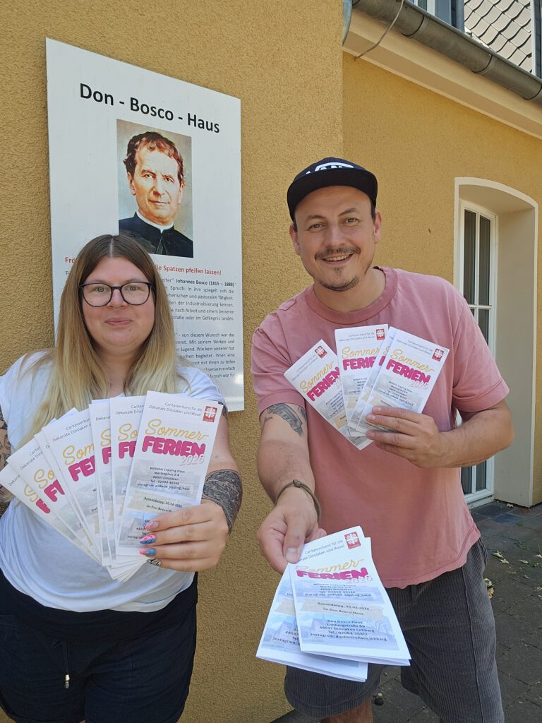 Mitarbeitende des Caritasverbandes für die Dekanate Dinslaken und Wesel halten den Flyer des Sommerferienprogrammes 2026 in die Kamera